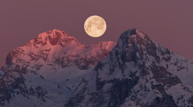 Full moon setting behind the mountains at sunrise. Photo by Ales Krivec
