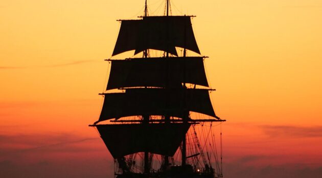 A tall ship silhouette sailing on the ocean during a sunset. La Rochelle, France. Photo by Rafael Garcin