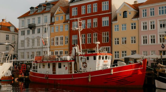 A red boat in Nyhavn, a famous 17th-century waterfront and entertainment district in the Indre By (Inner City) of Copenhagen, Denmark. Photo by Frank Huang