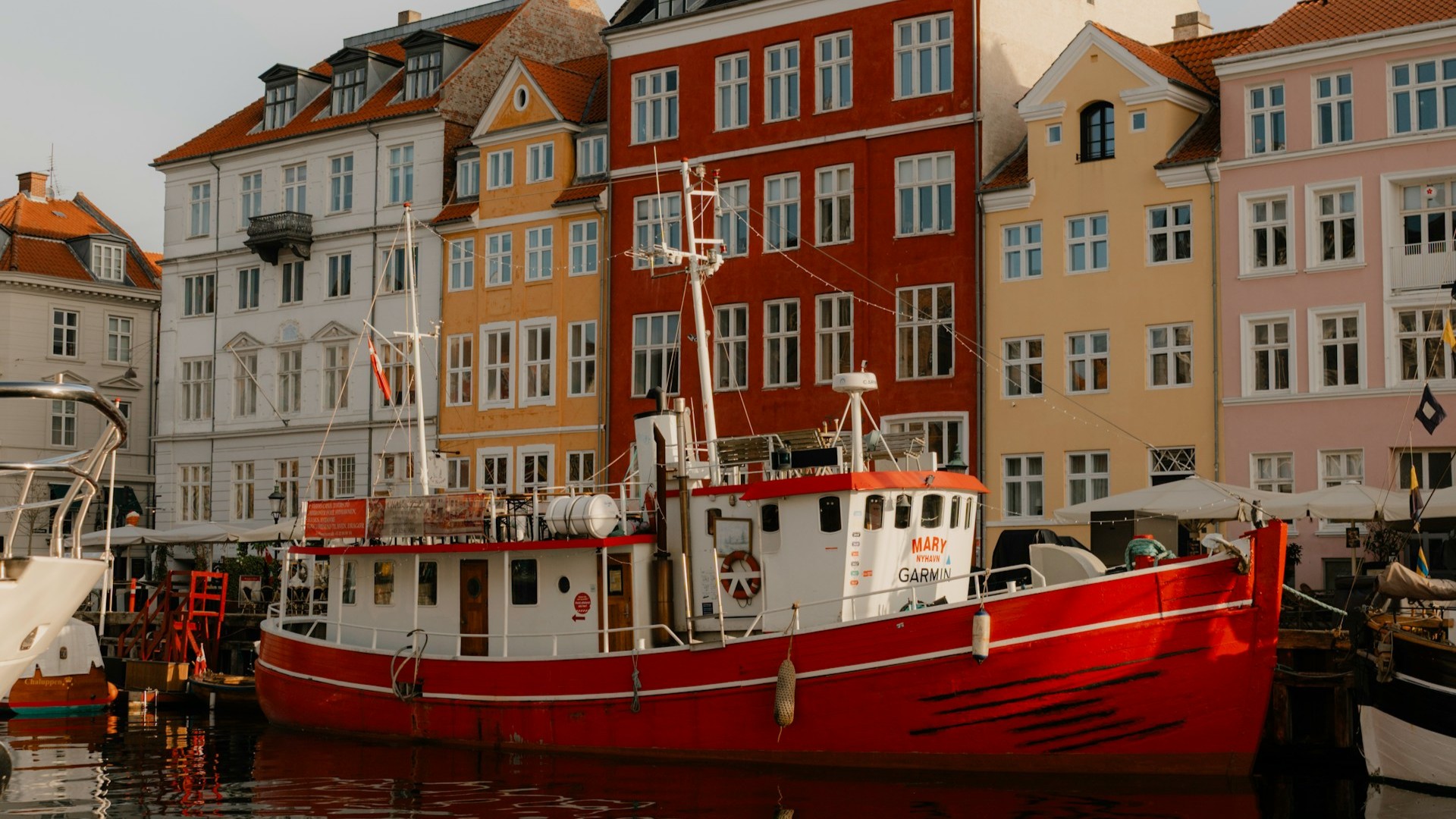 A red boat in Nyhavn, a famous 17th-century waterfront and entertainment district in the Indre By (Inner City) of Copenhagen, Denmark. Photo by Frank Huang